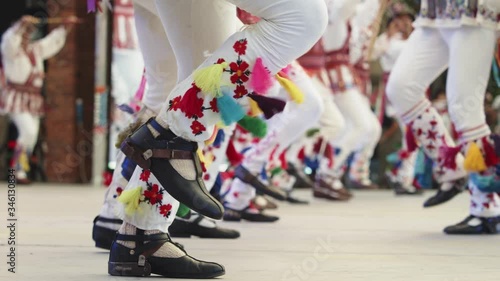 Calusari,  dansul Călușului - Romanian traditional dance.  Traditional romanian folklore dancers in traditional costumes dancing on stage in slow motion photo