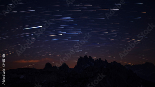 Canvas Print Mountain silhouettes with star trails in the night sky at Three Peaks in the Dolomite Alps , South Tyrol Italy