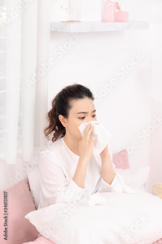 Sick woman with seasonal infections, flu, allergy lying in bed.