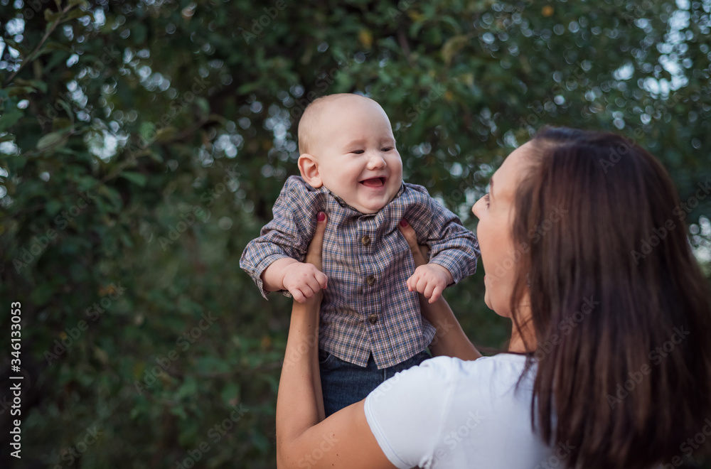 Fototapeta premium The baby laughs happily in maternal hands. Fun play with a kid