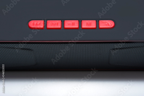 Portable wireless speaker isolated on a white background. Black sound speaker with control buttons.