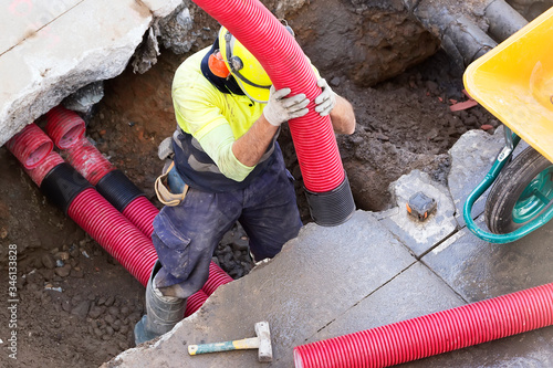 Fotografija construction worker for restoir and repair pipes for underground electrical wiri