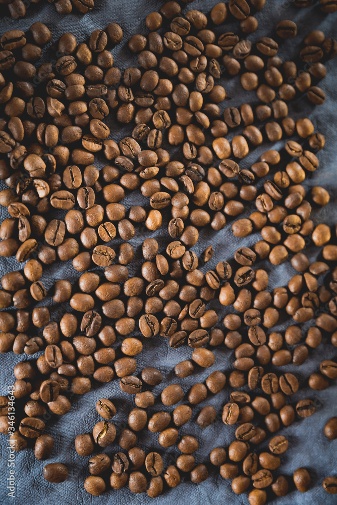 Dark roast coffee beans scattered on dark background. Coffee beans texture pattern, flat lay Dark roast coffee beans scattered on dark background. Coffee beans texture pattern, flat lay