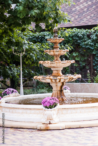 Beautiful fountain in garden. Water flows in the fountain