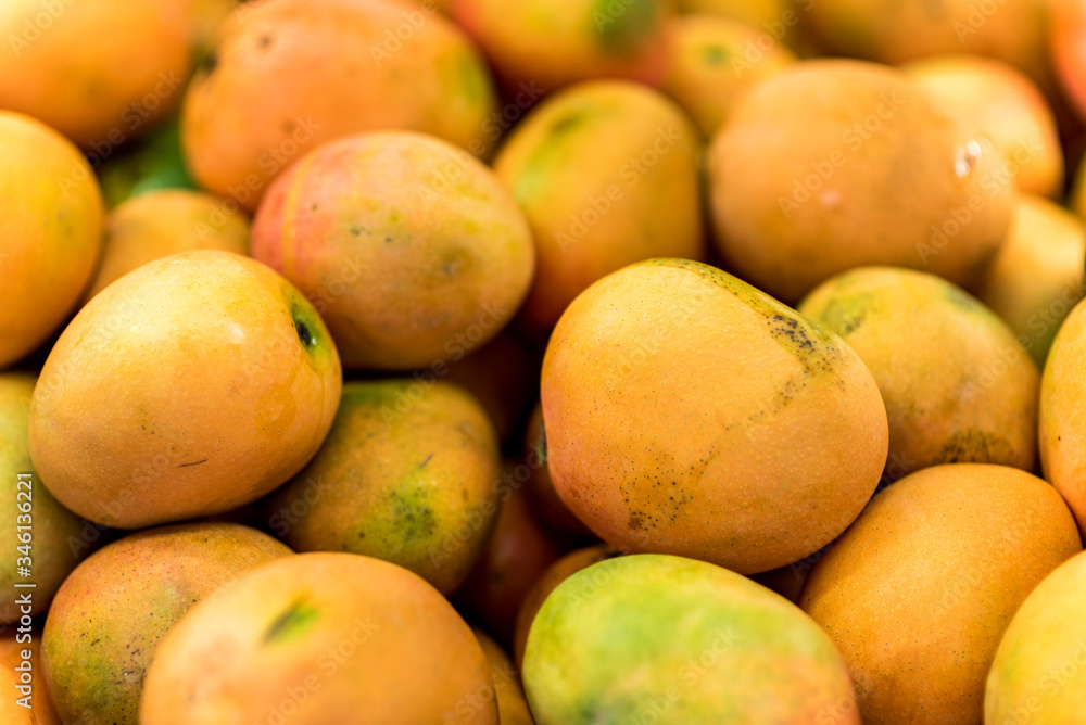 Close up of fresh mangos at food street market. Juicy mango fruit background