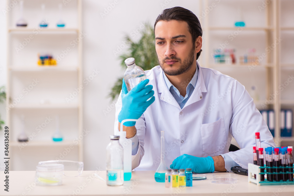 Young male chemist working in the lab Young male chemist working in the lab