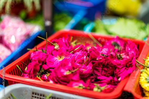 Fototapeta Naklejka Na Ścianę i Meble -  Basket full of flowers - small pink roses - sold at Indian street market. Floral offerings. Hindu ritual