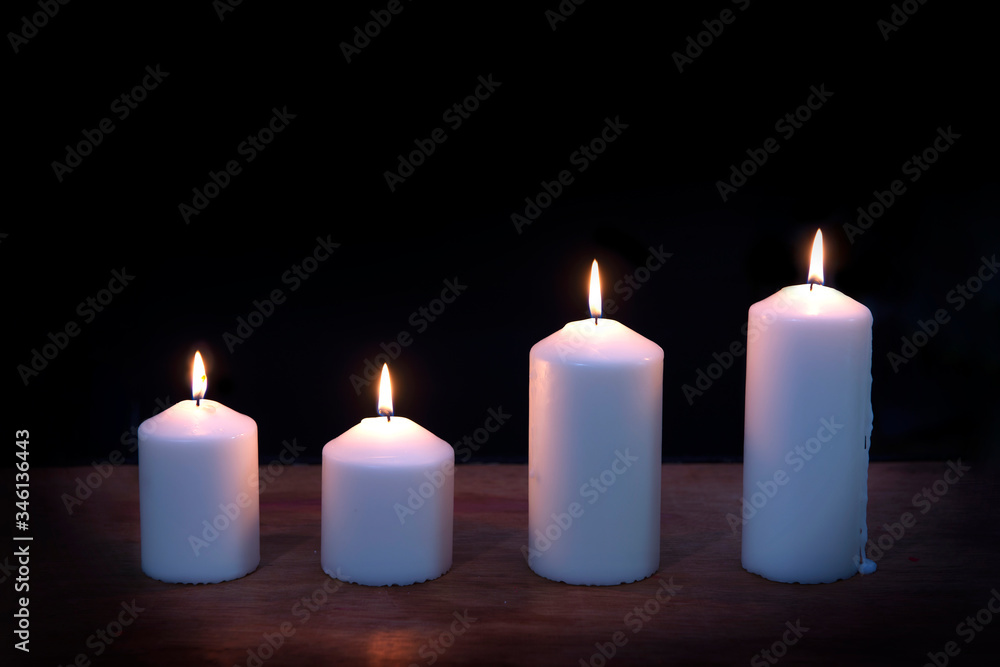 Close-up of  burning candles on black background..