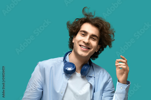 Quadro su tela Portrait of a young beautiful man wearing white t-shirt and blue shirt in blue h