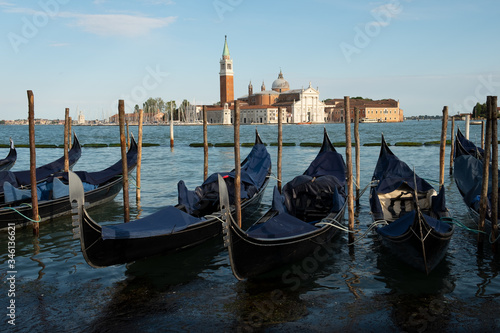 Góndolas atracadas en la laguna de Venecia con la basílica Di San Giorgo Maggiore al fondo.