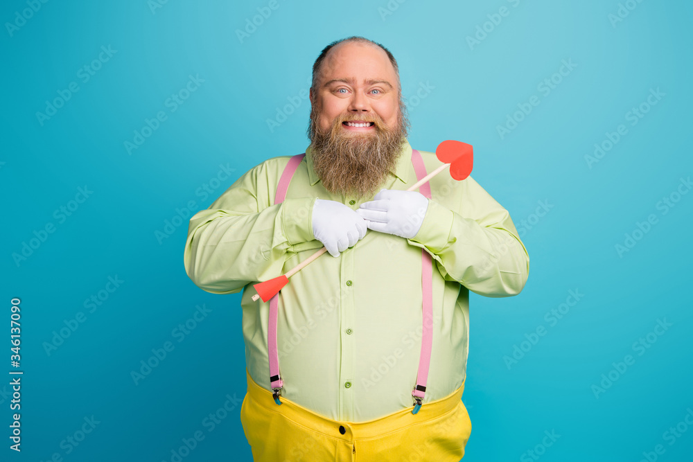 © deagreez - Portrait of his he nice funny funky dreamy affectionate cheerful cheery man cupid holding in hand hugging heart arrow isolated over bright vivid shine vibrant blue color background © deagreez - Portrait of his he nice funny funky dreamy affectionate cheerful cheery man cupid holding in hand hugging heart arrow isolated over bright vivid shine vibrant blue color background