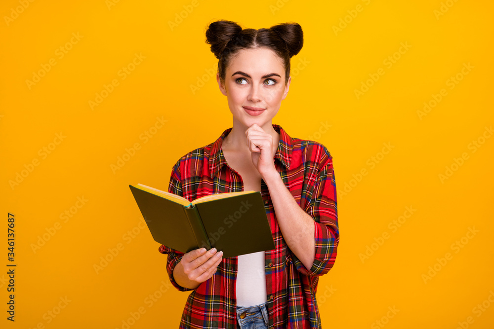 Photo of cute student lady two buns read story favorite novel look up empty space dreamer think over essay writing wear casual white red plaid shirt isolated yellow color background