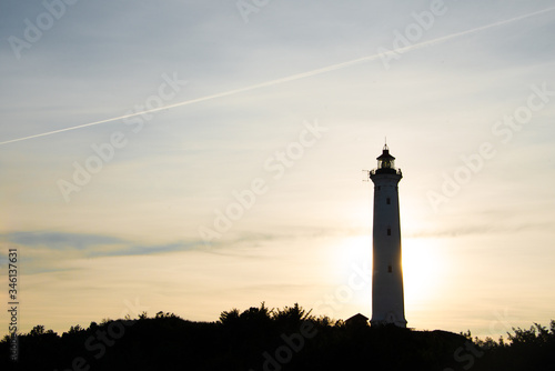 Foto Silhouette aus der Ferne - ein Leuchtturm an der Nordseeküste im Gegenlicht des