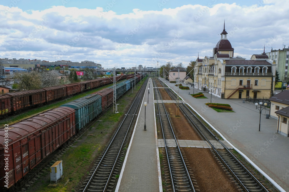 Naklejka premium Railway station in Lutsk Ukraine. Deserted area and station building. Freight cars. Morning industrial landscape. Top view. 