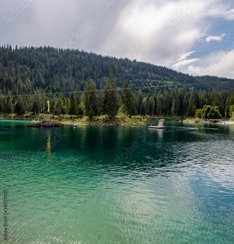 A green coniferous forest encircling a turqoise mountain lake