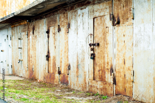 Iron garages in a row. Rusty, old doors and gates of garages.