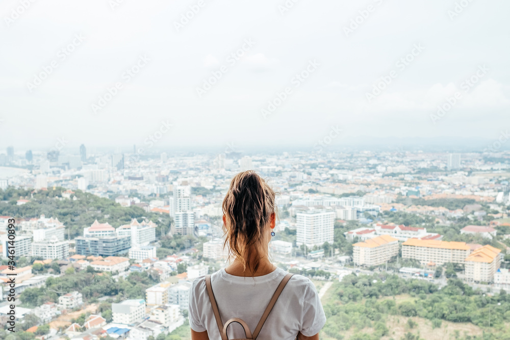 Young caucasian woman looking at the city from the heights