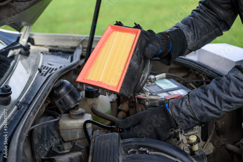 Man replaces a dirty air filter for a new one in a car. car service
