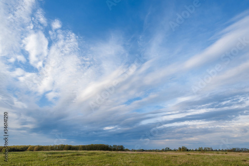 field and blue sky with clouds © Kaminski Vadim