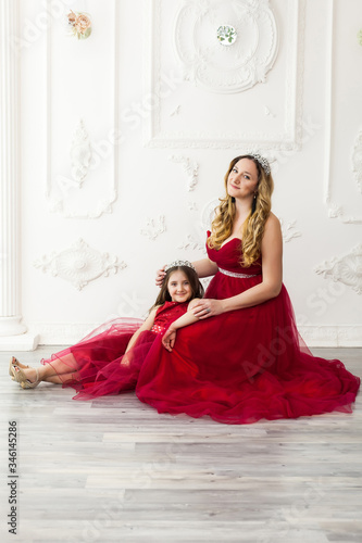 mother and daughter in same outfits posing in studio