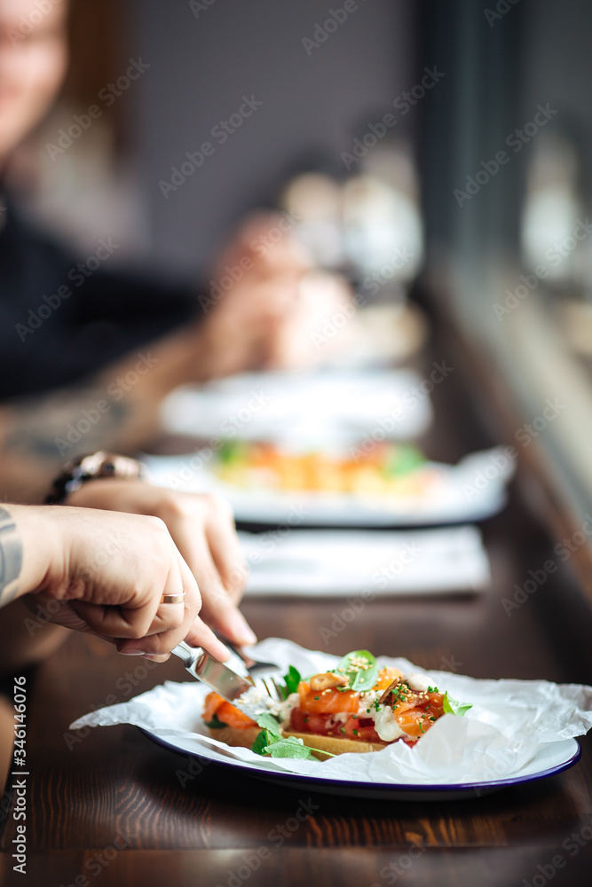 Male hands eating toast with salmon