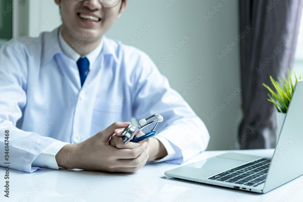 Fototapeta premium Asian doctor man wearing stethoscope white coat in his office hospital building.