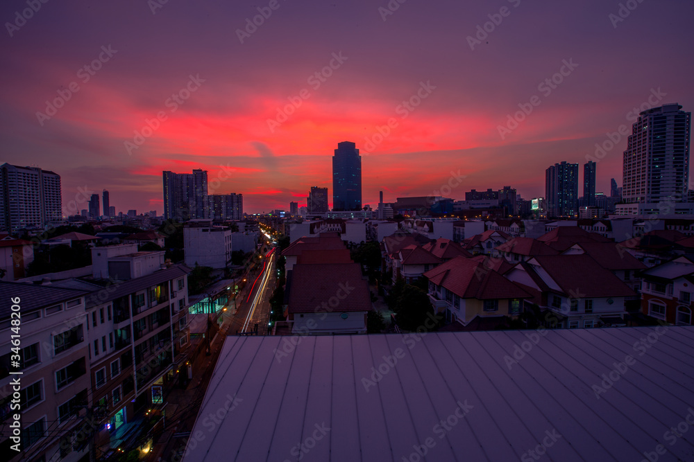 Fototapeta premium The high angle background of the city view with the secret light of the evening, blurring of night lights, showing the distribution of condominiums, dense homes in the capital community