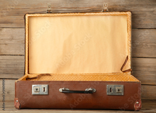 Open old leather portable suitcase for travel trip on grey background with copy space