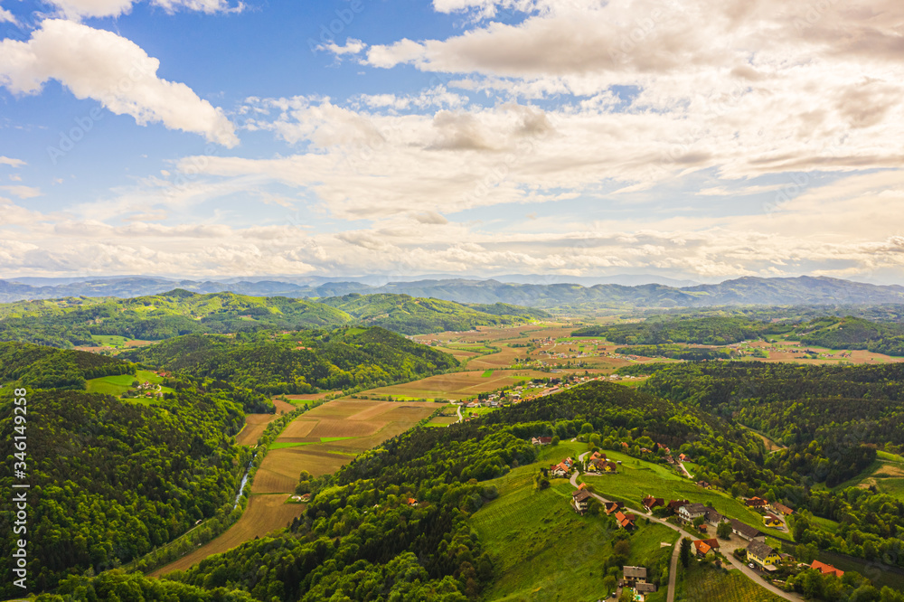 Aerial view of of green hills and vineyards with mountains in background