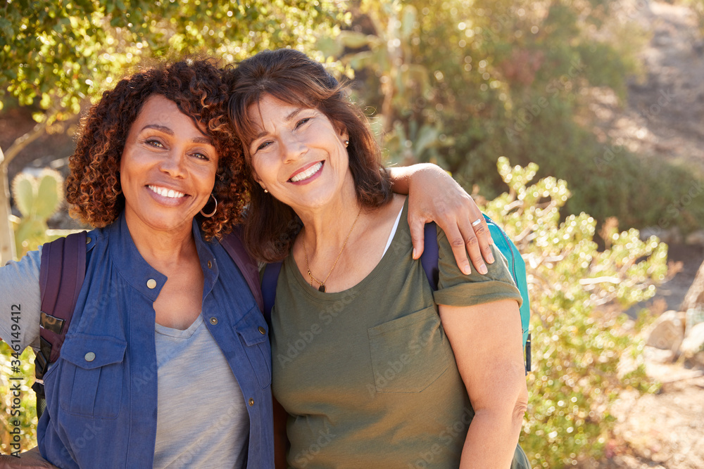 Portrait Of Two Senior Female Friends Hiking Along Trail In Countryside Together Portrait Of Two Senior Female Friends Hiking Along Trail In Countryside Together