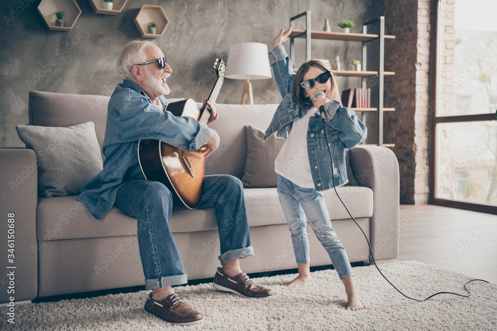 Photo of two people grandpa play guitar little granddaughter mic singing rejoicing cool style trendy sun specs denim clothes repetition school concert stay home quarantine living room indoors - obrazy, fototapety, plakaty 