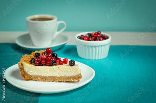 New York style Cheesecake on white plate decorated with fresh berries  on table with copy space so sweet and delicious. Homemade bakery concept.