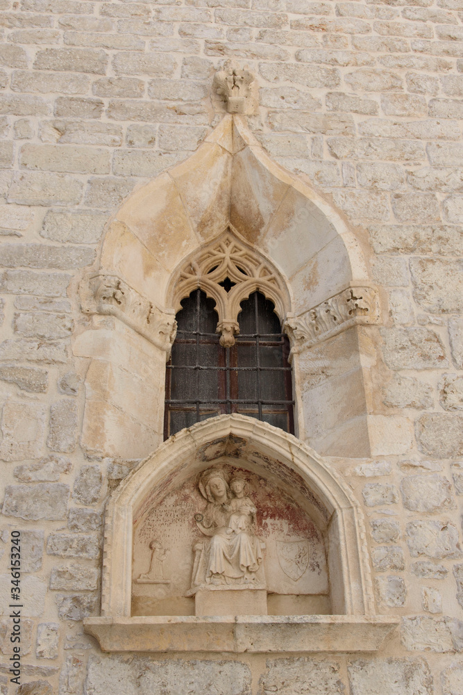 Window in a stone facade with altar underneath, in Sibenik, Croatia, Europe, situated next to the mouth of the river Krka on the Adriatic Sea coast