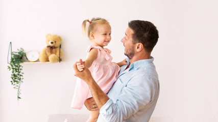 Caucasian dad holding his cute lovely daughter