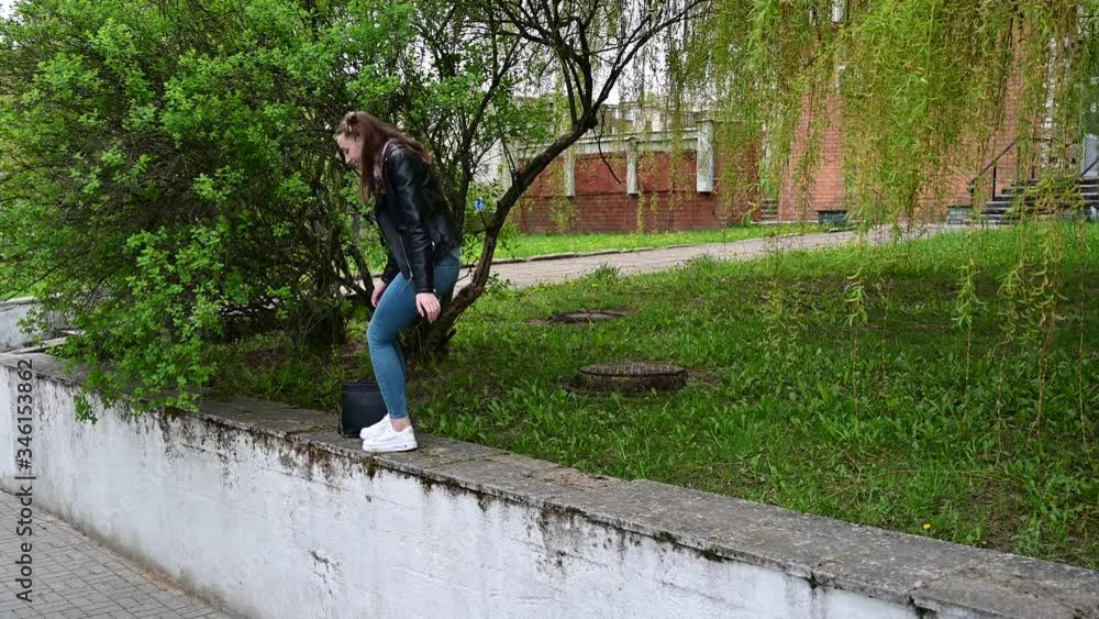 Video portrait of a young girl smiling steps in full growth on a street in a city in a park Video portrait of a young girl smiling steps in full growth on a street in a city in a park