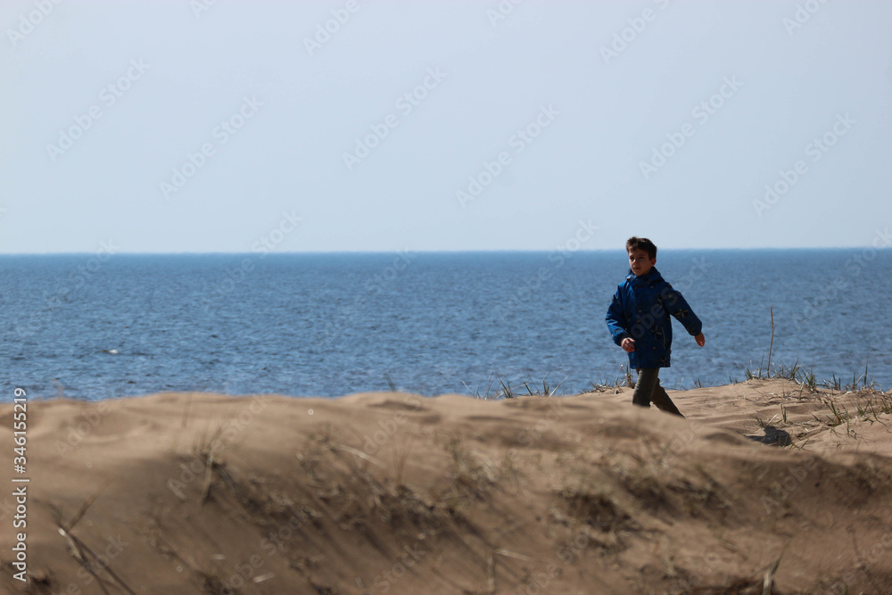 young man walking on the beach sand dunes on the shore of baltic sea