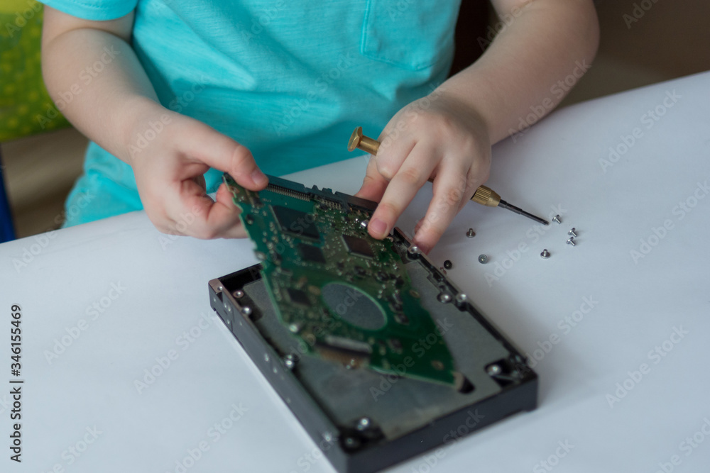 An inquisitive child is experimenting with a broken hard drive An inquisitive child is experimenting with a broken hard drive