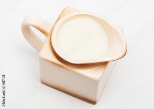 Beige milk jug on white background