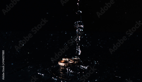 wedding rings with the water splash on black background