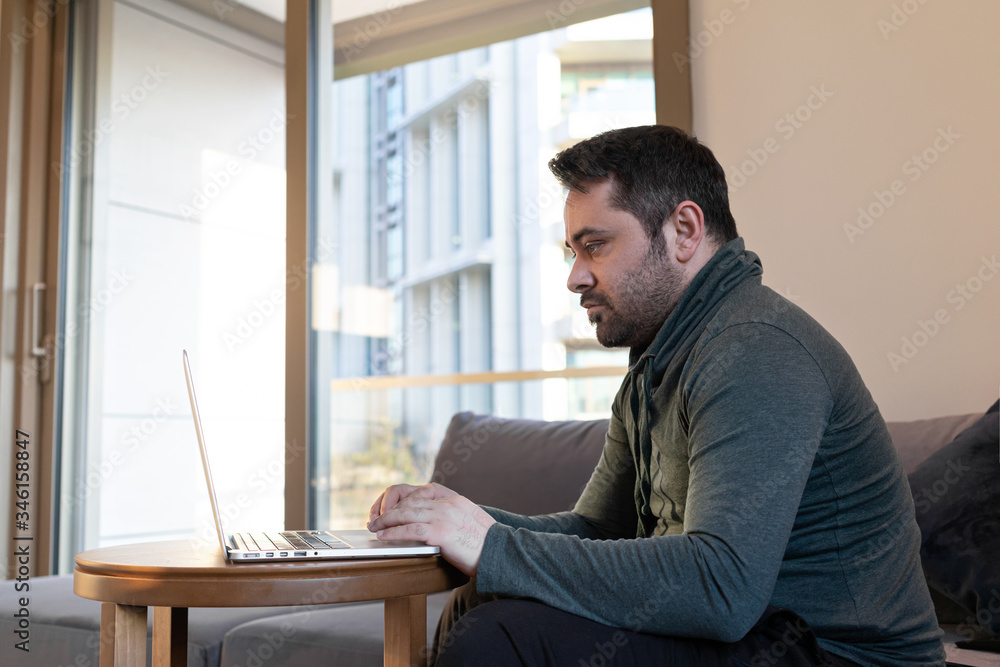 man working online at home or study using laptop on sofa. Stay home quarantine, Remote working