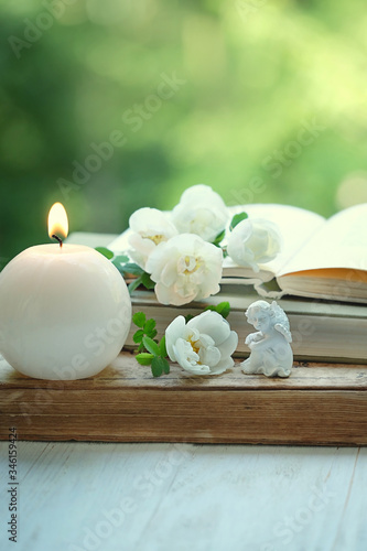 Fototapeta Naklejka Na Ścianę i Meble -  angel, candle, flowers and old book. romantic relax still life. concept of faith, Christianity religion