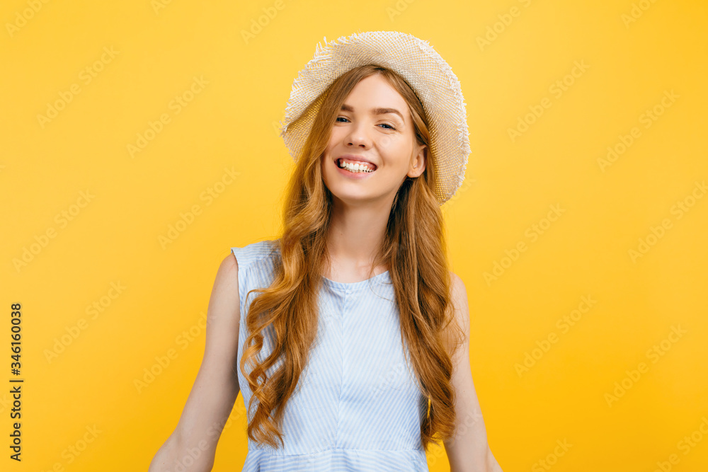 young girl in a summer hat, dressed in summer clothes, smiling on an isolated yellow background young girl in a summer hat, dressed in summer clothes, smiling on an isolated yellow background