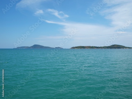 Panoramic view of the islands. Sea. Seascape. Land is on the horizon, view from the sea, blue sky, white cloud. Smooth azure water. Panorama. Calmness and serenity. Andaman sea, Thailand, Phuket.