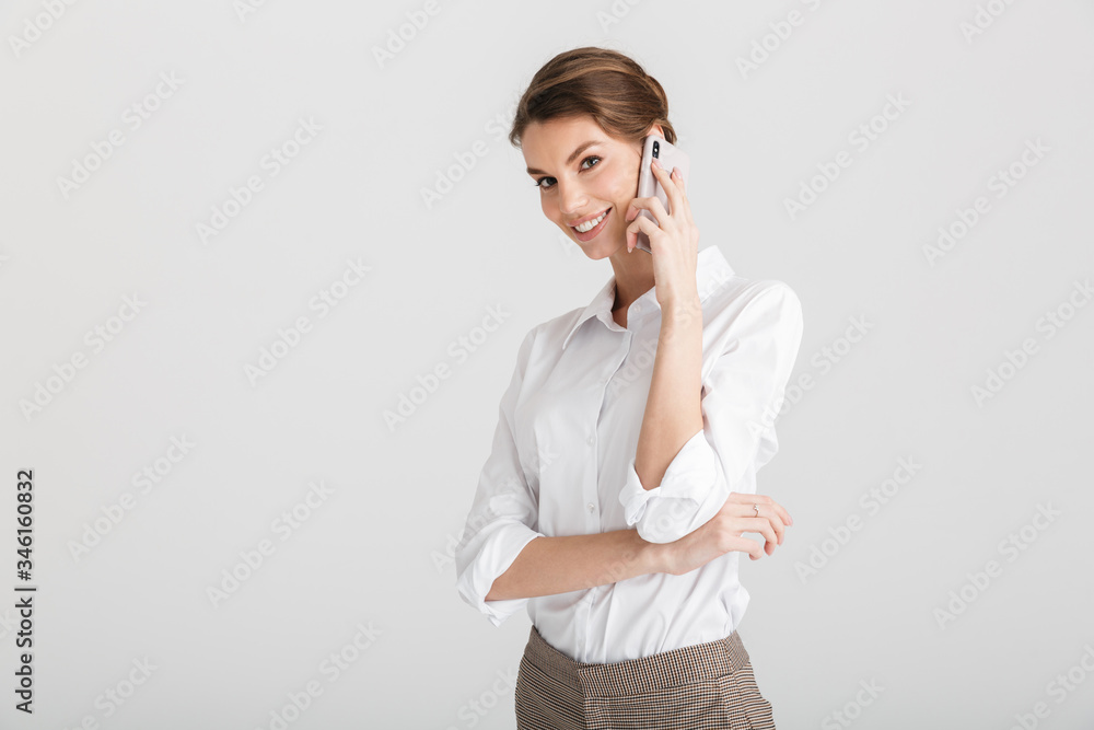 Image of pleased beautiful woman smiling and talking on mobile phone Image of pleased beautiful woman smiling and talking on mobile phone