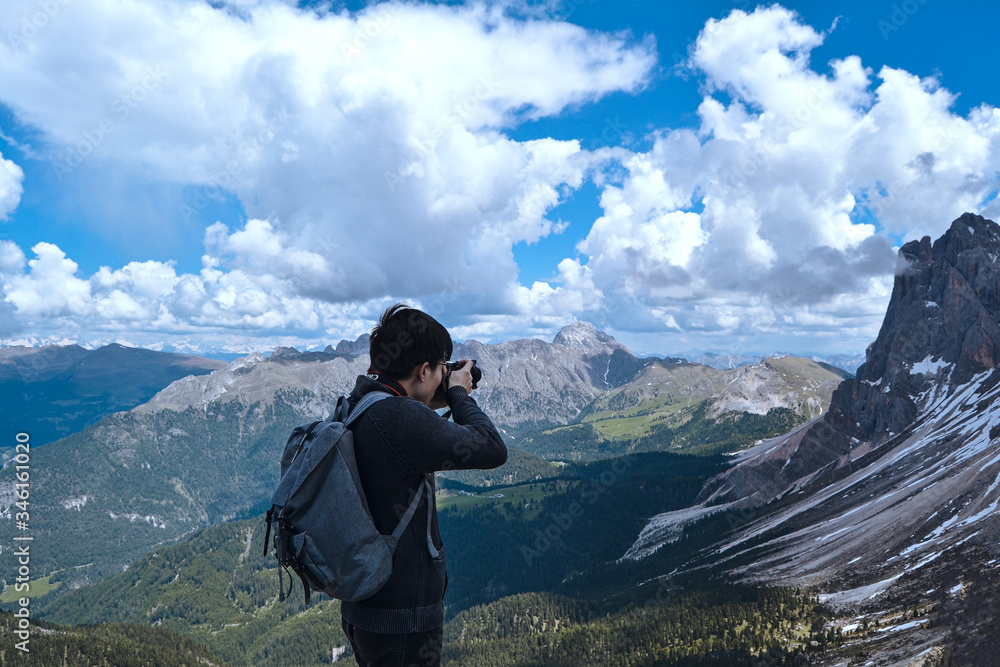 young man take a photo in the mountains. Seceda in Italy. 