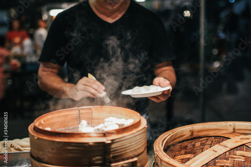 Asian Culture Street food booth selling Chinese specialty Steamed Dumplings preparation cooking in a bamboo basket at restaurant Chinese food.Assortment of different types of asian traditional.