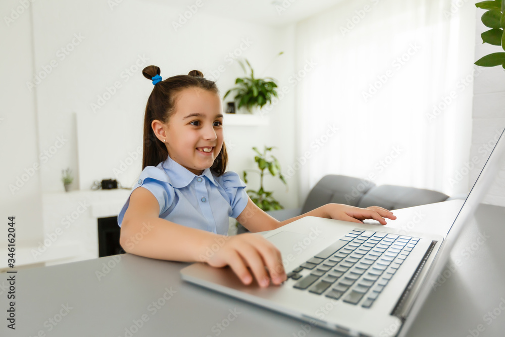 Pretty stylish schoolgirl studying homework math during her online lesson at home, social distance during quarantine, self-isolation, online education concept, home schooler Pretty stylish schoolgirl studying homework math during her online lesson at home, social distance during quarantine, self-isolation, online education concept, home schooler