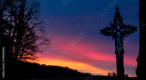 Farbenfroher Sonnenuntergang mit Jesuskreuz