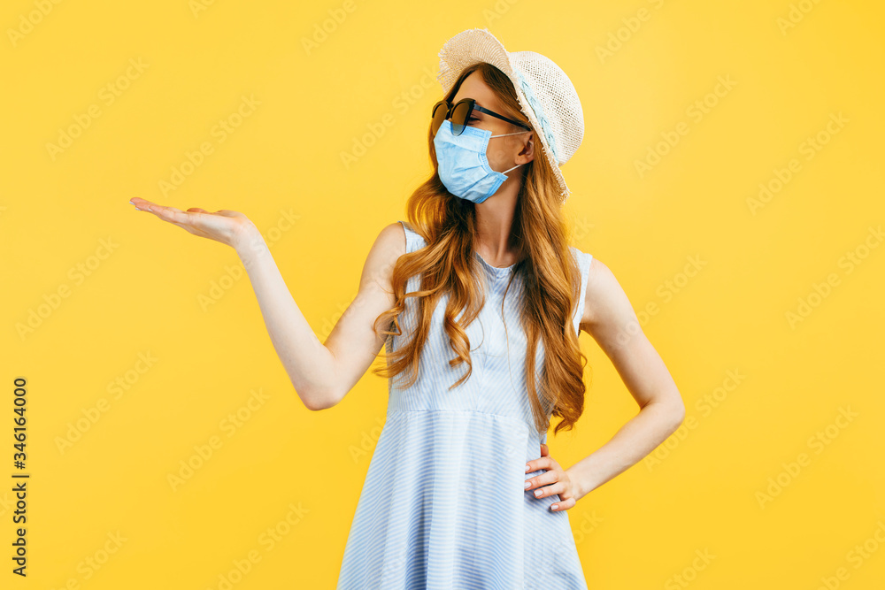a girl in a hat in summer, wears a medical protective mask against a viral infection, on a yellow isolated background. Quarantine, coronavirus, summer