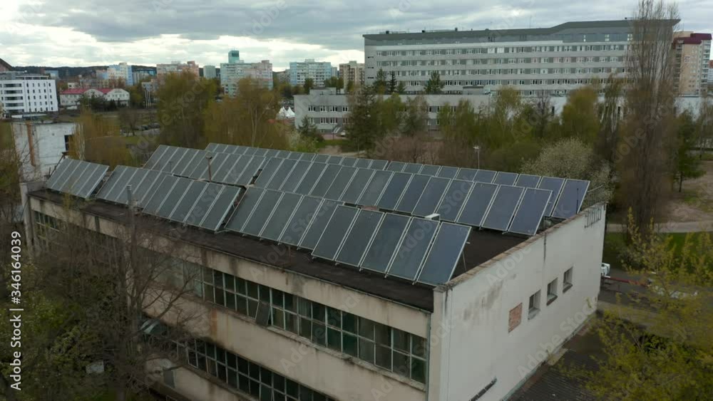 Aerial view of an abandoned factory with solar panels on a flat roof, providing renewable sun energy from the sun. Ecological production of electricity without environment pollution Aerial view of an abandoned factory with solar panels on a flat roof, providing renewable sun energy from the sun. Ecological production of electricity without environment pollution